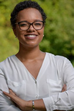 Genç ve güzel bir Afro-Amerikan iş kadını yaz sıcağında bir parkta..