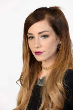 Tasması beyaz arka planda olan düşünceli genç bir bayan..