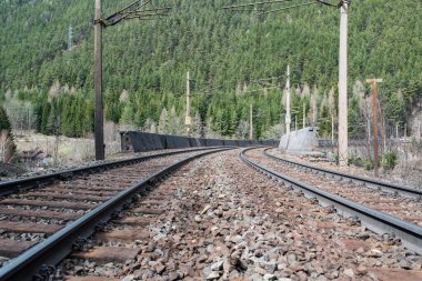 Arka planda bir dağ olan iki paralel tren yolu boyunca görüntüle.