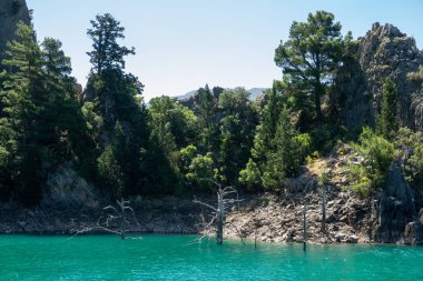 Temiz turkuaz suyla göl manzarası ve Yeşil Kanyon 'un dağ kayalıkları. Yeşil Kanyon, Manavgat, Antalya, Türkiye