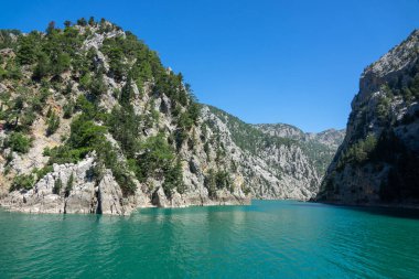 Temiz turkuaz suyla göl manzarası ve Yeşil Kanyon 'un dağ kayalıkları. Yeşil Kanyon, Manavgat, Antalya, Türkiye