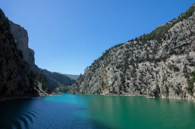 Temiz turkuaz suyla göl manzarası ve Yeşil Kanyon 'un dağ kayalıkları. Yeşil Kanyon, Manavgat, Antalya, Türkiye