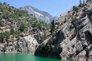 Temiz turkuaz suyla göl manzarası ve Yeşil Kanyon 'un dağ kayalıkları. Yeşil Kanyon, Manavgat, Antalya, Türkiye
