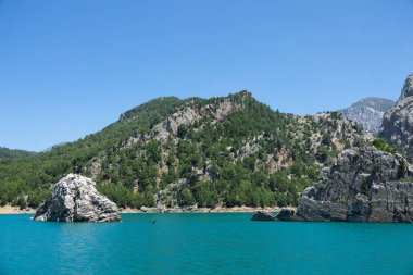 Temiz turkuaz suyla göl manzarası ve Yeşil Kanyon 'un dağ kayalıkları. Yeşil Kanyon, Manavgat, Antalya, Türkiye