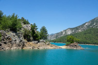 Temiz turkuaz suyla göl manzarası ve Yeşil Kanyon 'un dağ kayalıkları. Yeşil Kanyon, Manavgat, Antalya, Türkiye