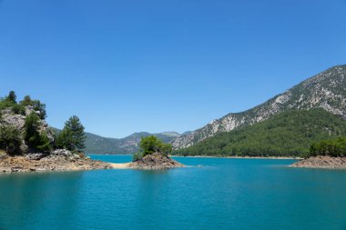 Temiz turkuaz suyla göl manzarası ve Yeşil Kanyon 'un dağ kayalıkları. Yeşil Kanyon, Manavgat, Antalya, Türkiye