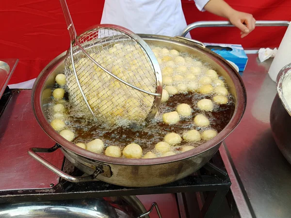 Kaynar yağda kızartılmış krema topları pişirmek. Türk Donutları Lokma