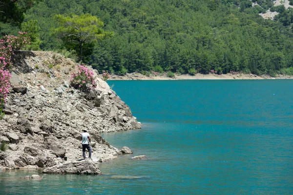 Manavgat, Türkiye - Haziran 05, 2019: Bir balıkçı Yeşil Kanyon 'daki dağ kayalıkları arasında bir gölde balık yakalıyor