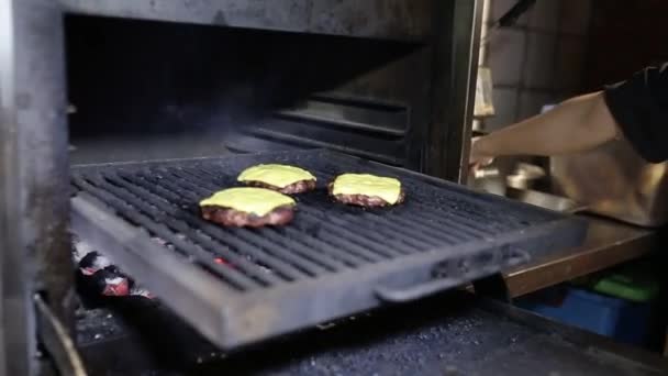 Bucătarul pregătește o bucată de carne pentru un burger în cuptor. Burger patty . — Videoclip de stoc