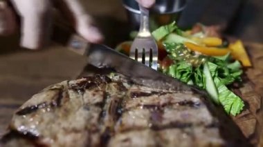 Biftek dilimlenmiş ve sosa batırılmış.