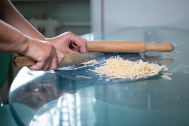 Tanınmayan bir kadın erişte keser. Kadınların elleri yakın plan..