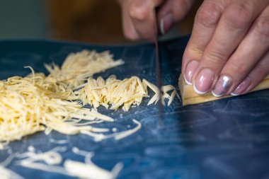 Tanınmayan bir kadın erişte keser. Kadınların elleri yakın plan..