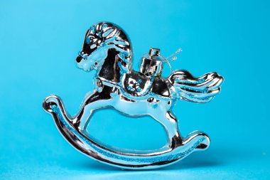 Mavi arka planda bir at şeklinde Noel ağacı oyuncağı.