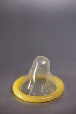 Gri arka planda yakın plan prezervatif. Doğum kontrol cihazı. HIV enfeksiyonu