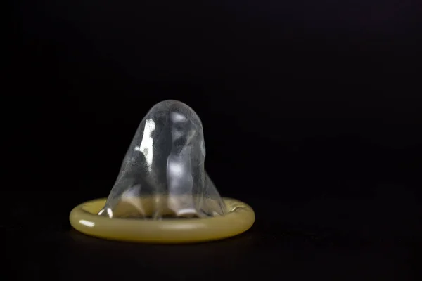 Preservativo Amarelo Close Isolado Fundo Preto — Fotografia de Stock