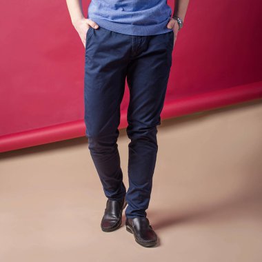 Arka planda kot pantolon giyen erkek bacakları.