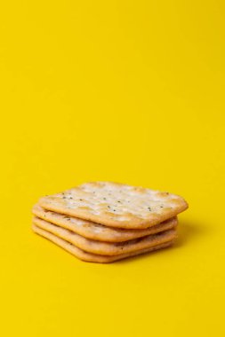 Sarı arka planda tuzlu ve baharatlı kraker
