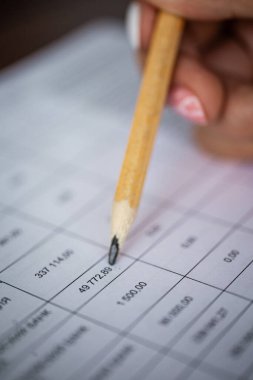 Üzerinde numaralar olan kağıt ve kalem. kontrol raporu.