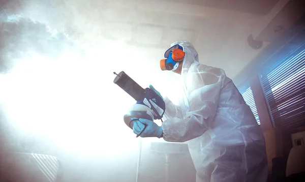 Um profissional desinfecta a sala com um anti-séptico. — Fotografia de Stock