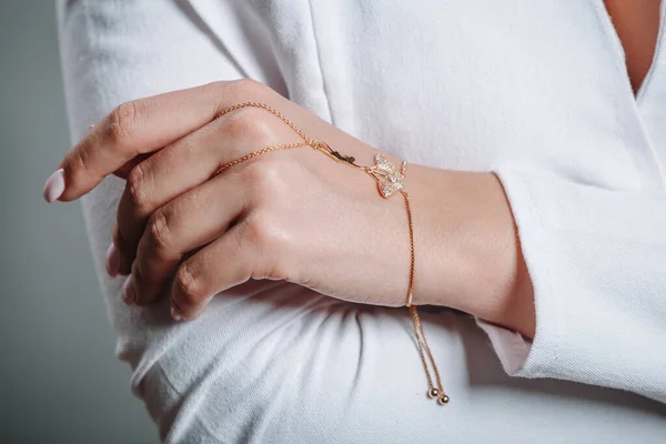 Uma menina com uma pulseira de ouro fino em seu braço — Fotografia de Stock