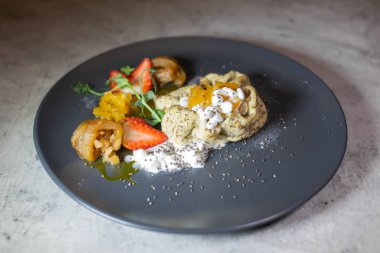 Süzme peynirli çilekli ve meyveli bir restoranda krep servis etmek.