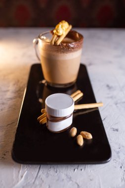 Çikolata ezmeli kahve ve siyah tabakta kurabiye..