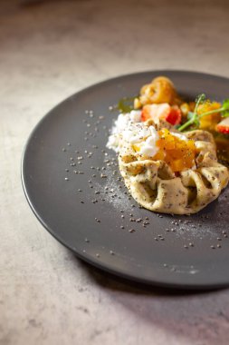 süzme peynirli gözleme ve gri tabakta meyve.