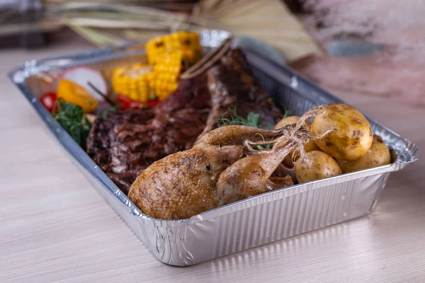 Folyo kutusunda sağlıklı restoran yemeği teslimatı. Izgara biftek ve sebze. Paket yemek..