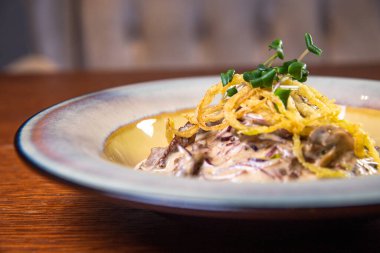 Soslu et ve patatesli turta tabağında otlar..