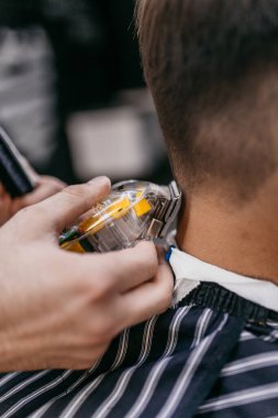 berber, berber dükkanında saç kesmek için saç makasıyla tarak kullanıyor..