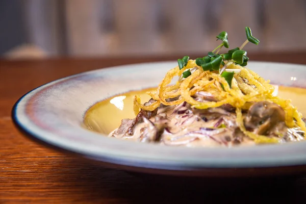 Soslu et ve patatesli turta tabağında otlar..