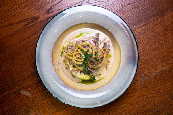 Üst Manzara. Soslu et ve patatesli turta tabağında otlar..