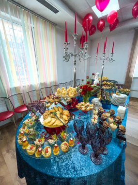 Mavi masa örtüsüyle yemek servisi yapan şenlikli bir masa..