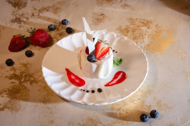 Beyaz bir tabakta çilekli hindistan cevizi tatlısı.