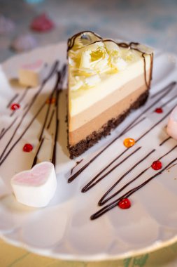 Tabakta üç katmanlı çikolatalı pasta ve güzel bir servis.