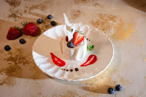 Beyaz bir tabakta çilekli hindistan cevizi tatlısı.