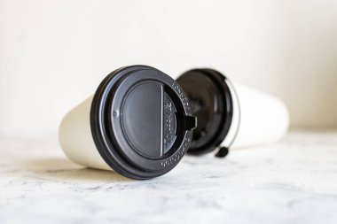 Arka planda beyaz karton kahve fincanları var.