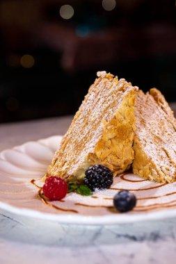 Beyaz tabakta böğürtlenli Napolyon tatlısı..