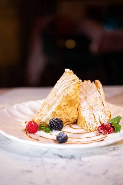 Beyaz tabakta böğürtlenli Napolyon tatlısı..