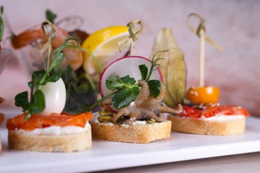 Beyaz bir tabakta farklı bruschetta çeşitleri..