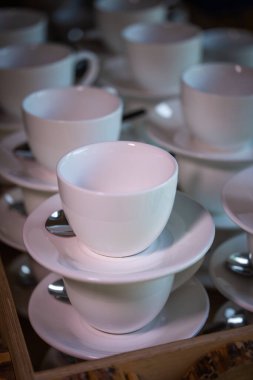 Kahve ve çay için bir sürü beyaz kupa ya da bardak üst üste dururlar.