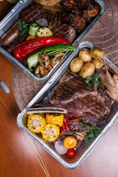 Teslimat için et yemekleri. Biftek, sosis ve tavuklu üst manzara..