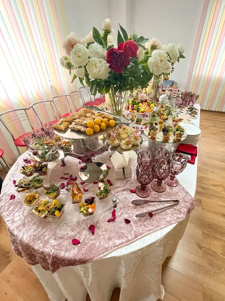 Çiçeklerle süslenmiş çok çeşitli lezzetli yemeklerle dolu bir şenlik masası..