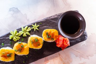 Japon yemeği, siyah tabakta peynirli pirinç rulosu..