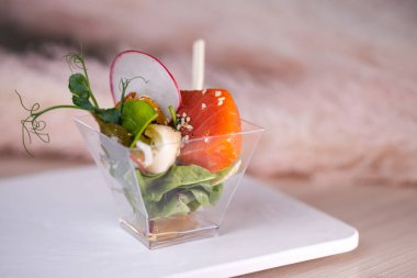 Açık büfedeki plastik bardakta balıklı salata..