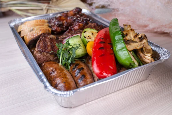 delivery of meat dishes in a foil box.