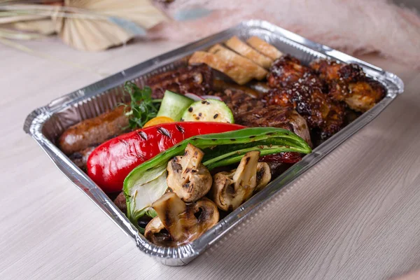 delivery of meat dishes in a foil box.