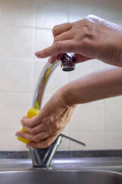 Mutfak temizliği. Bir kadın lavaboyu beyaz bir süngerle yıkıyor..