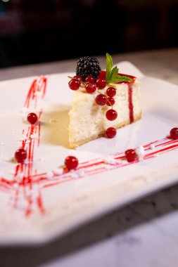 Beyaz tabakta yaban mersinli yumuşak cheesecake..