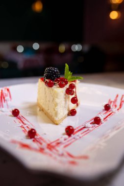 Beyaz tabakta yaban mersinli yumuşak cheesecake..